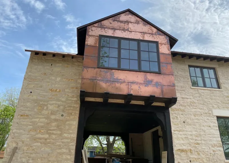 Copper metal panel facade on a stone building for Skylight Installation in Fletcher