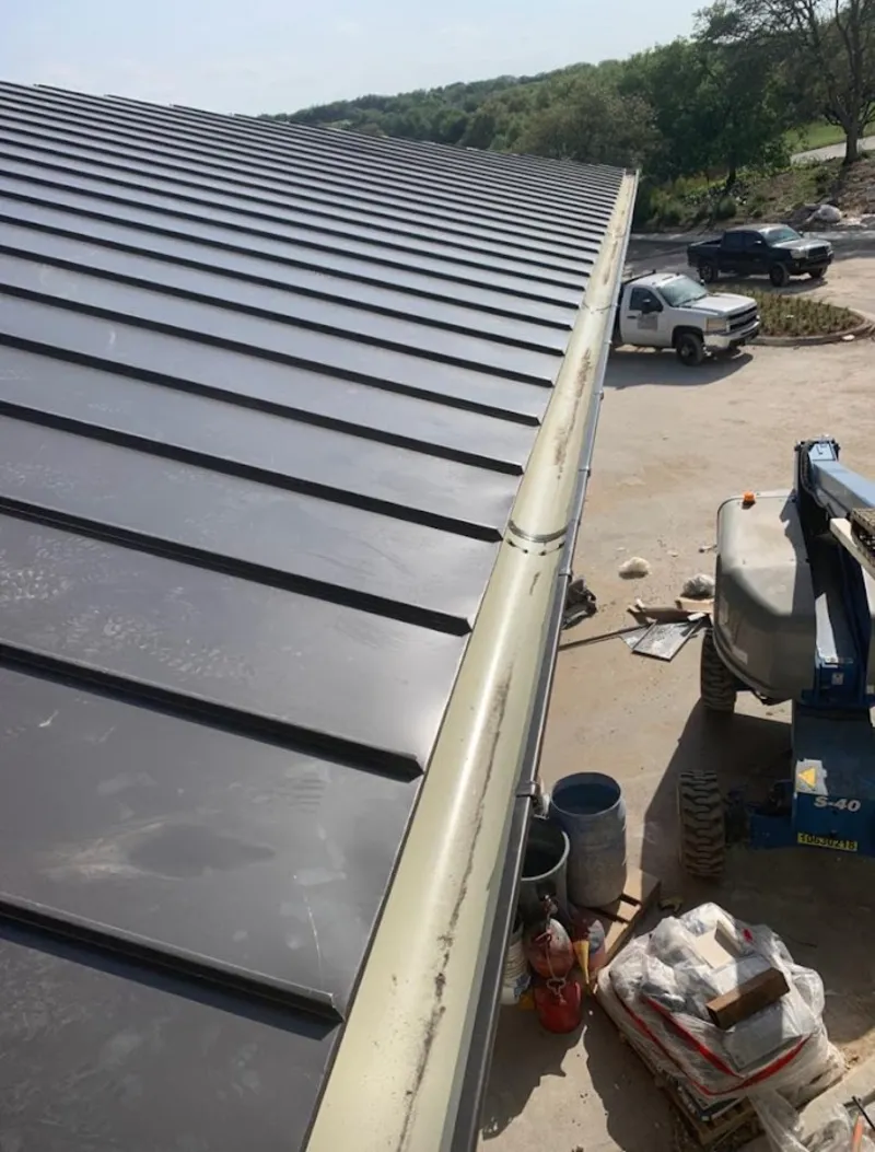 Standing seam panel and gutter detail on a metal roofing jobsite in Fletcher
